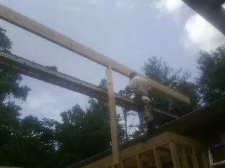 Carpenter setting a ridge beam over a new addition frame — Ice Dam Removal by Roofing Brothers in East Rutherford