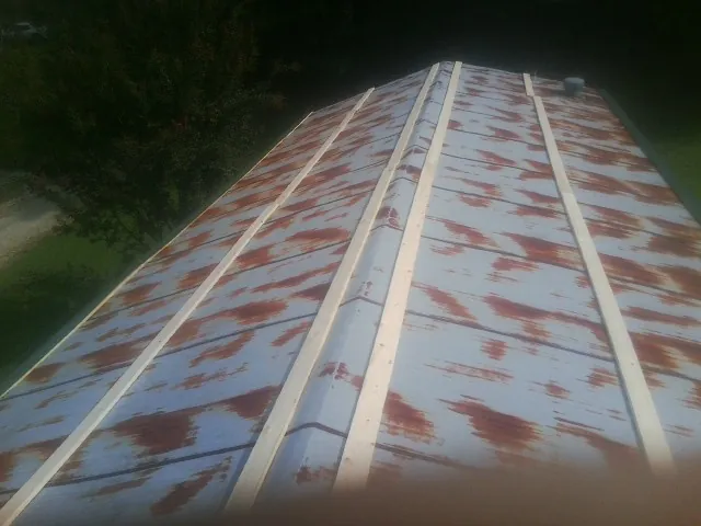 Rusted metal roof panels with new wood purlins before replacement — Storm Damage Roof Repair in East Rutherford by Roofing Brothers