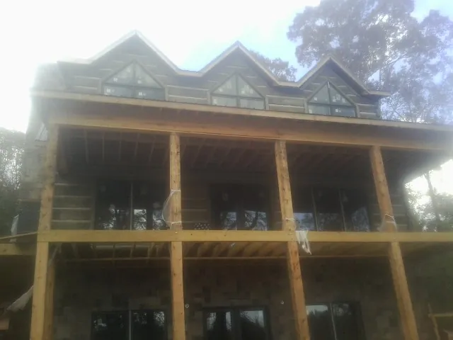 Dormers and porch framing on a large log home under construction — Roof Coating work by our crew in East Rutherford