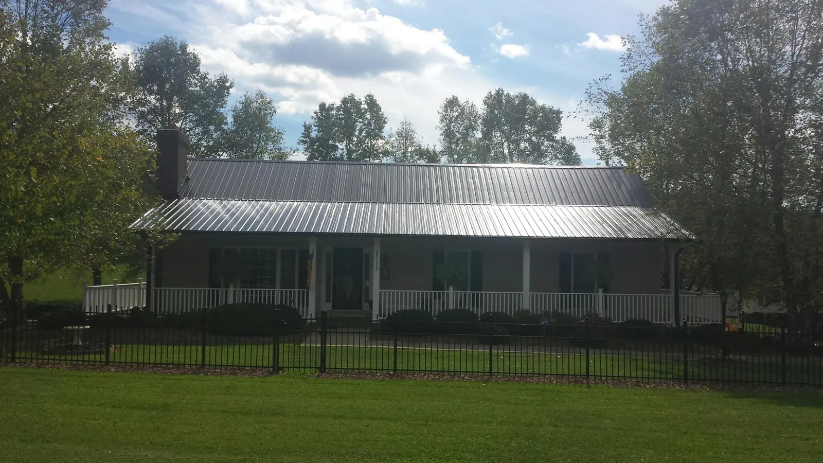 Gray metal roof on a brick ranch with a full width front porch — Gutter Guard Installation work by our crew in East Rutherford